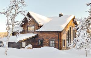 韦姆达伦Gorgeous Home In Vemdalen With Sauna的雪覆盖着雪覆盖的树木的房子