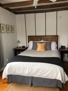 布罗姆湖AUBERGE Knowlton的一间卧室配有一张大床和木制床头板