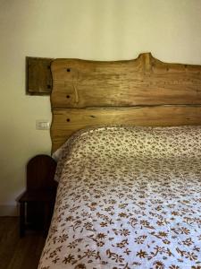 巴尼奥迪罗马涅Casina del Ponte的卧室内的一张床位,配有木制床头板