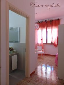 托雷苏达Dimora tra gli ulivi的客厅设有粉红色的墙壁和镜子
