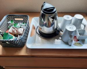 伯恩茅斯斯图尔特山酒店 的盘子上的茶壶,桌上有一个篮子