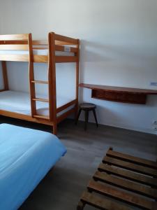 圣皮耶尔基贝龙Home des Pins SARL的一间卧室配有双层床和书桌