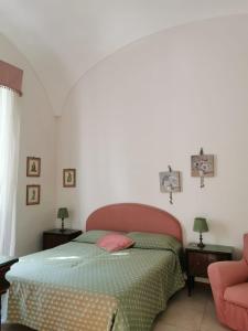 加埃塔OASI DI PACE A GAETA的一间卧室配有一张床和一张粉红色的椅子