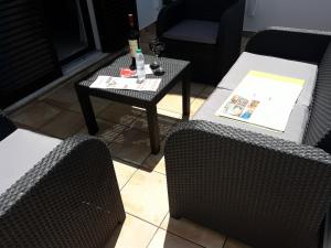 珀彻斯Familia Brito的客厅配有两把椅子和一张桌子及一瓶葡萄酒