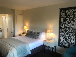 基督城托斯卡纳汽车旅馆的卧室配有一张床,墙上有标志