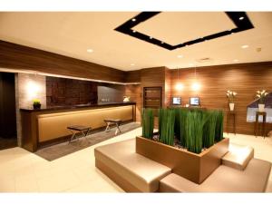 岐阜Hotel Il Credo Gifu - Vacation STAY 84624的大堂设有等候室,配有桌子和植物