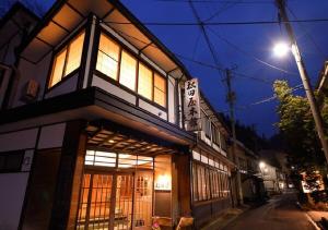 花卷市Dai Onsen Matsudaya Ryokan - Vacation STAY 67479的街上的一座建筑,晚上有窗户