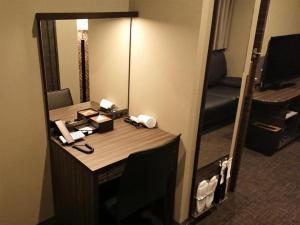 东京Act Hotel Roppongi - Vacation STAY 85367的一张位于酒店客房的桌子,配有镜子