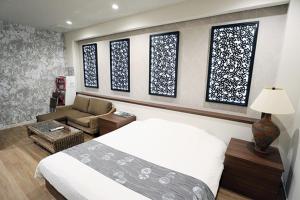 诹访市Lex Suwa (Adult Only)的一间卧室配有一张床、一张沙发和窗户。