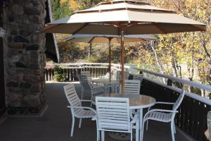 沃特顿公园北国住宿加早餐旅馆的阳台配有桌椅和遮阳伞