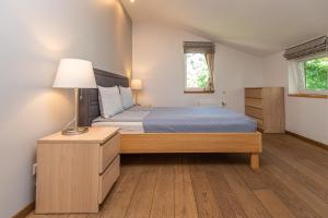 帕兰加S11公寓的一间卧室配有一张床和一盏灯,铺有木地板