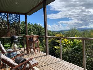 班加洛Callemondah Studio with stunning views, in Bangalow and Byron Hinterland的甲板上配有椅子和桌子