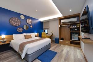曼谷Aspira One Sutthisan的一间卧室设有一张大床和蓝色的墙壁
