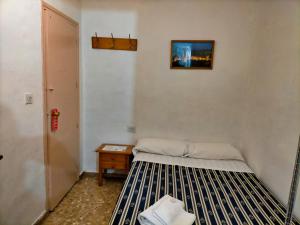格拉纳达格拉纳达AB膳食公寓的小房间,设有床和床头柜