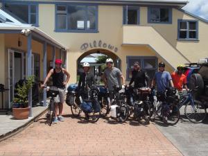 奥雷瓦奥雷瓦枕头旅舍的一群人站在建筑物前面,骑着自行车