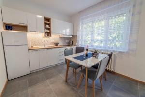 诺维萨德Apartman Danube lux的厨房配有白色橱柜和桌椅