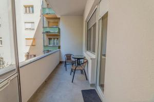 诺维萨德Apartman Danube lux的阳台配有2把椅子和桌子
