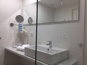 帕尔马海滩Oleander的白色的浴室设有水槽和镜子