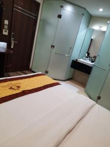 胡志明市Prague Saigon Airport Hotel的一间带白色大床的卧室和一间浴室