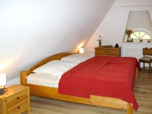 博恩Apartment Spitzgatt by Interhome的一间卧室配有一张带红色毯子的木床