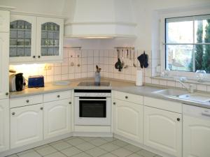 卢布明Holiday Home Am Walde by Interhome的厨房配有白色橱柜和水槽