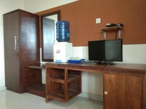 庞岸达兰Hotel Abad Baru 1的客房设有一张带电视和显示器的书桌。