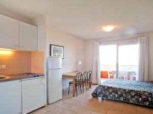 圣弗洛朗Apartment Suarella-2 by Interhome的厨房以及带1张床和1张桌子的卧室
