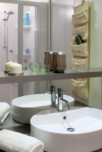 佩斯基耶拉德加达Casa mobile-Camping Bella Italia的浴室设有白色水槽和带毛巾的架子。