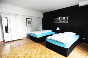 科隆Dorya am Ring的配有黑色墙壁和木地板的客房内的两张床