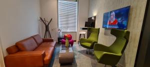 美因河畔法兰克福克里斯托尔法兰克福市酒店的客厅配有沙发、椅子和平面电视。