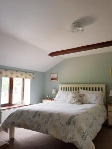 Narborough2 Barge Cottage的一间卧室配有一张带花卉床罩的大床