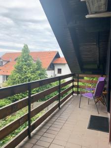 KomendaEla's Apartment的坐在房子阳台上的紫色椅子