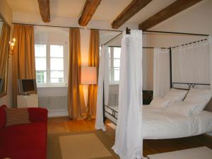雷根斯堡金色克鲁兹酒店的一间卧室配有天蓬床和红色沙发
