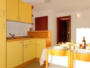 普纳特Apartment Barbara - PUT121 by Interhome的厨房配有黄色橱柜和桌椅
