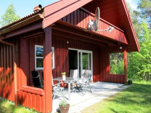 MjåvatnChalet Saglia - SOO020 by Interhome的红色小屋,在庭院里配有桌椅