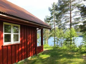 MjåvatnChalet Saglia - SOO020 by Interhome的水边的红色房子,有窗子