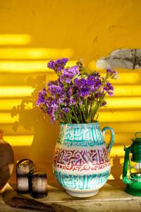 奥德米拉The Hobbit House - Montes da Ronha的花瓶,桌子上装有紫色花