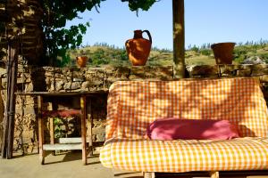 奥德米拉The Hobbit House - Montes da Ronha的一张沙发,坐在石墙前