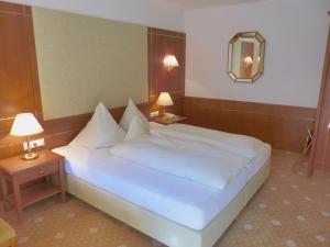 瑟弗浩斯卡尼萨夏酒店的卧室配有一张带两张桌子的大型白色床