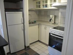 奥胡斯Guesthouse Sharon Aarhus的厨房配有白色冰箱和炉灶。 顶部烤箱