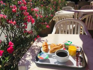 马诺斯克马诺斯克美丽阿尔卑斯酒店的桌上的早餐盘,包括咖啡和羊角面包