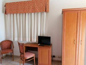 莫杜尼奥花园酒店的客房设有书桌、电视和椅子