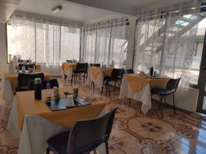 科皮亚波Hotel Pulmahue的用餐室设有桌椅和窗户。