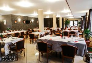 蒂米什瓦拉皮尔拉酒店的一间设有白色桌椅的用餐室