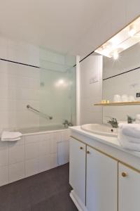奥尔西讷阿鲁姆酒店的白色的浴室设有浴缸和水槽。