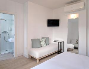 格拉纳达Broz Hostel的白色的客房设有床和浴室。