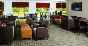 史云顿斯温顿西智选假日酒店的一间设有桌椅和窗户的等候室
