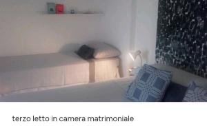 吉诺萨滨海CASA ADA的一张卧室的照片,卧室里配有一张床和一盏灯