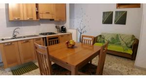 吉诺萨滨海CASA ADA的一间带木桌的厨房和一间带沙发的厨房