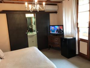 胡安莱潘玛尔乔莱娜酒店的一间卧室配有一张床,梳妆台上配有电视